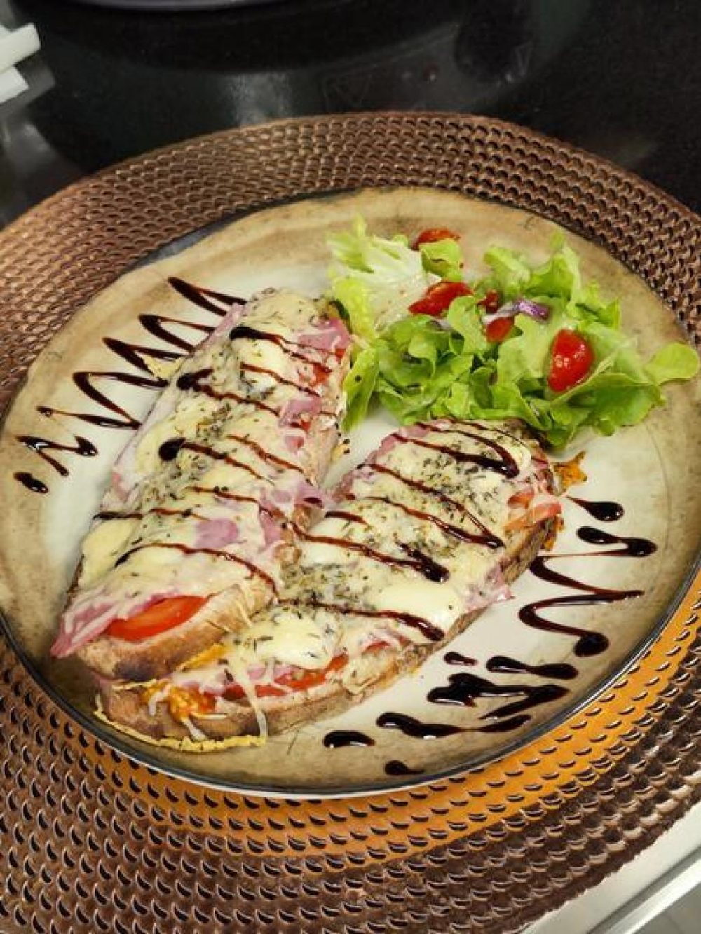 Deux tartines gratinées et une salade verte, dans une assiette à reflets cuivrés